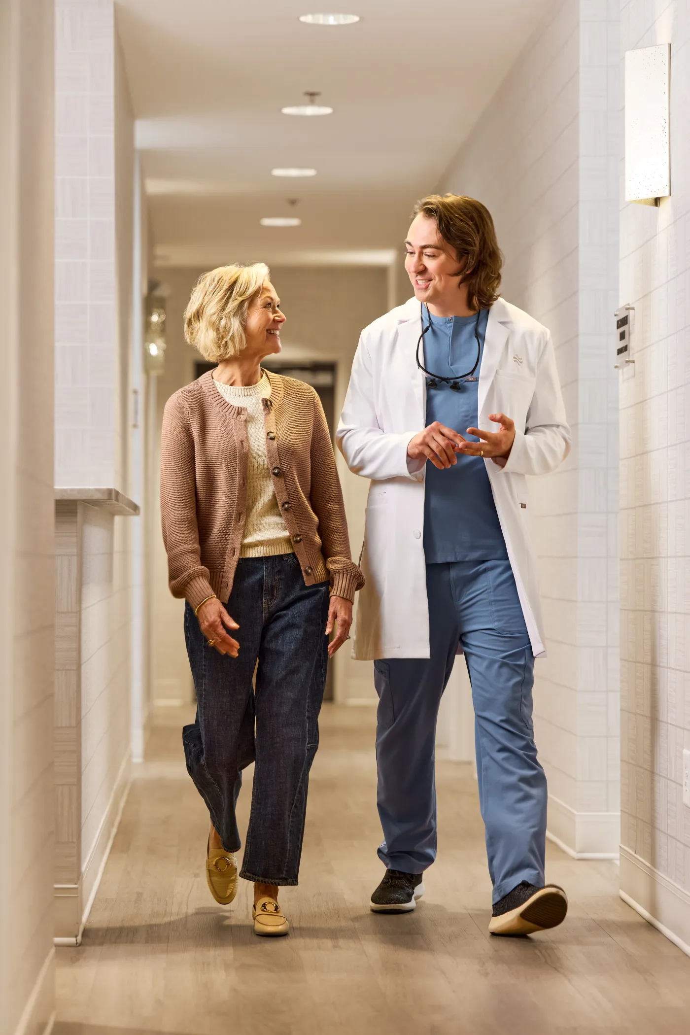 QualDerm clinician walking with a patient in a clinic hallway