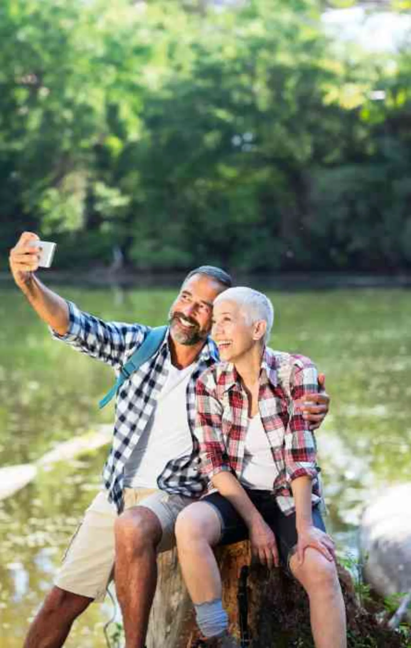 Miracle-Ear lifestyle image of an older couple taking a photograph outdoors